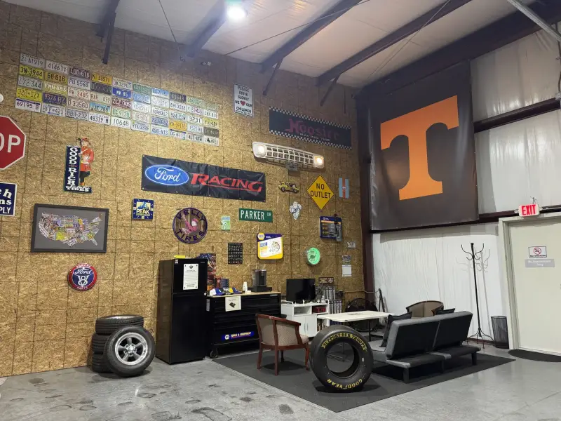 The customer lounge at Blessed Beginnings: a couch, a Tennessee Vols flag and a wall of old license plates